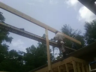 Carpenter setting a ridge beam over a new addition frame — Ice Dam Removal by Roofing Brothers in Countyline
