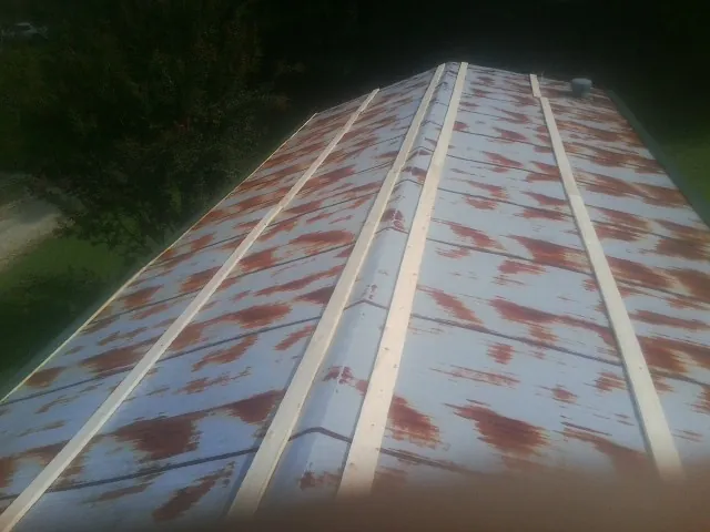 Rusted metal roof panels with new wood purlins before replacement — Storm Damage Roof Repair in Countyline by Roofing Brothers