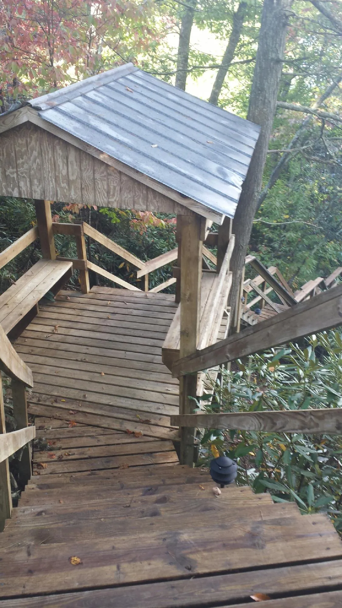 Metal roofed shelter over wooden steps on a wooded walkway — Skylight Repair & Installation work by our crew in Countyline