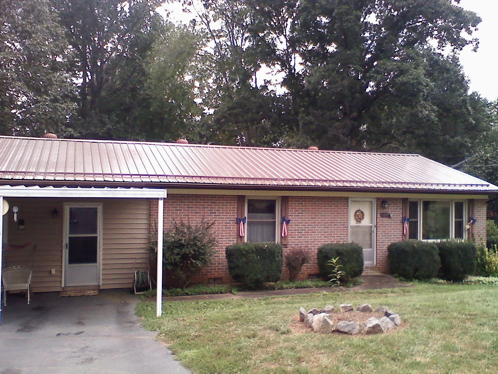 Bronze metal roof and carport on a brick ranch home — Roof Repair work by our crew in Countyline
