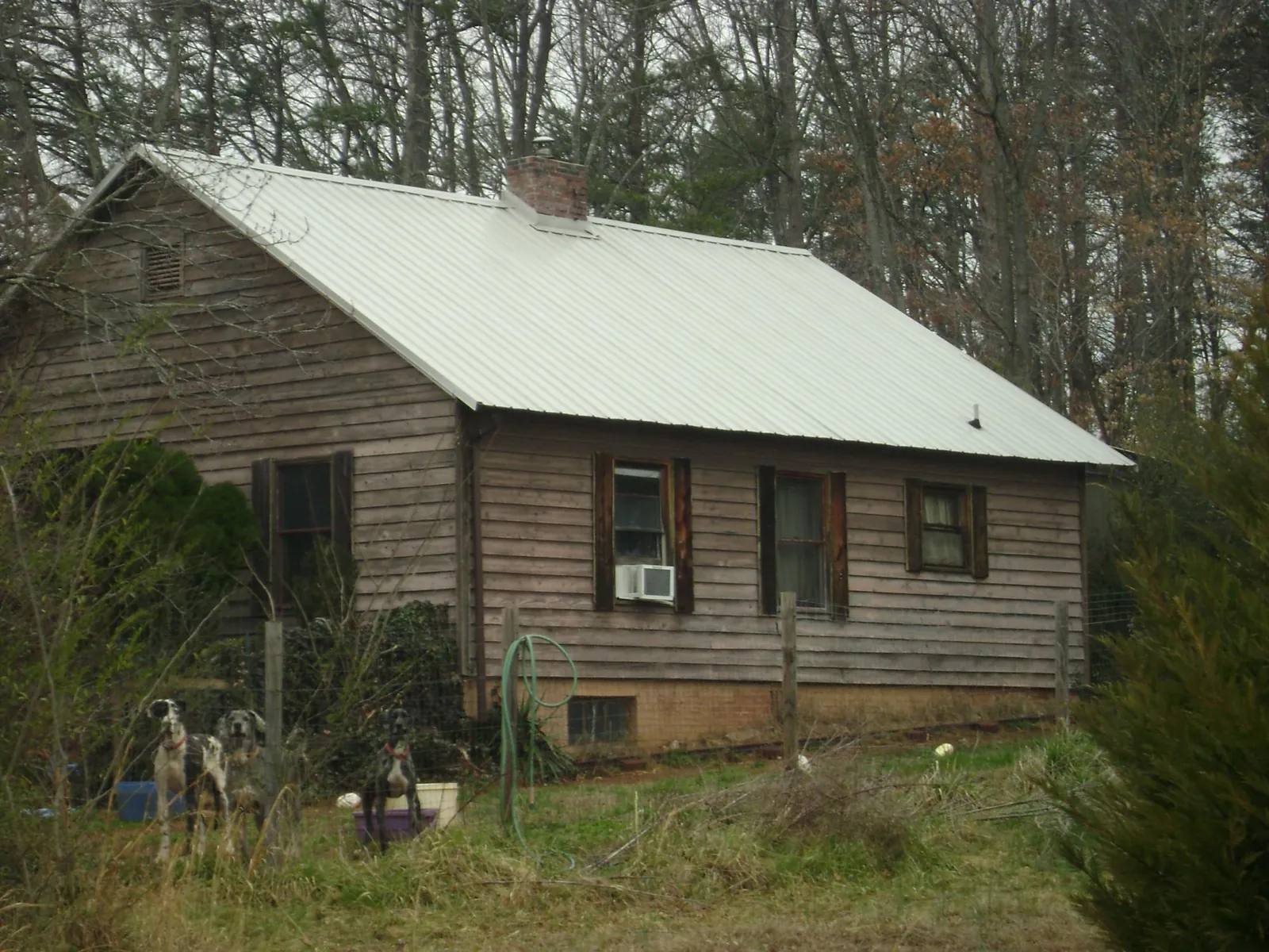 White metal roof on an old wood sided farmhouse, from a Metal Roof Installation job in Countyline