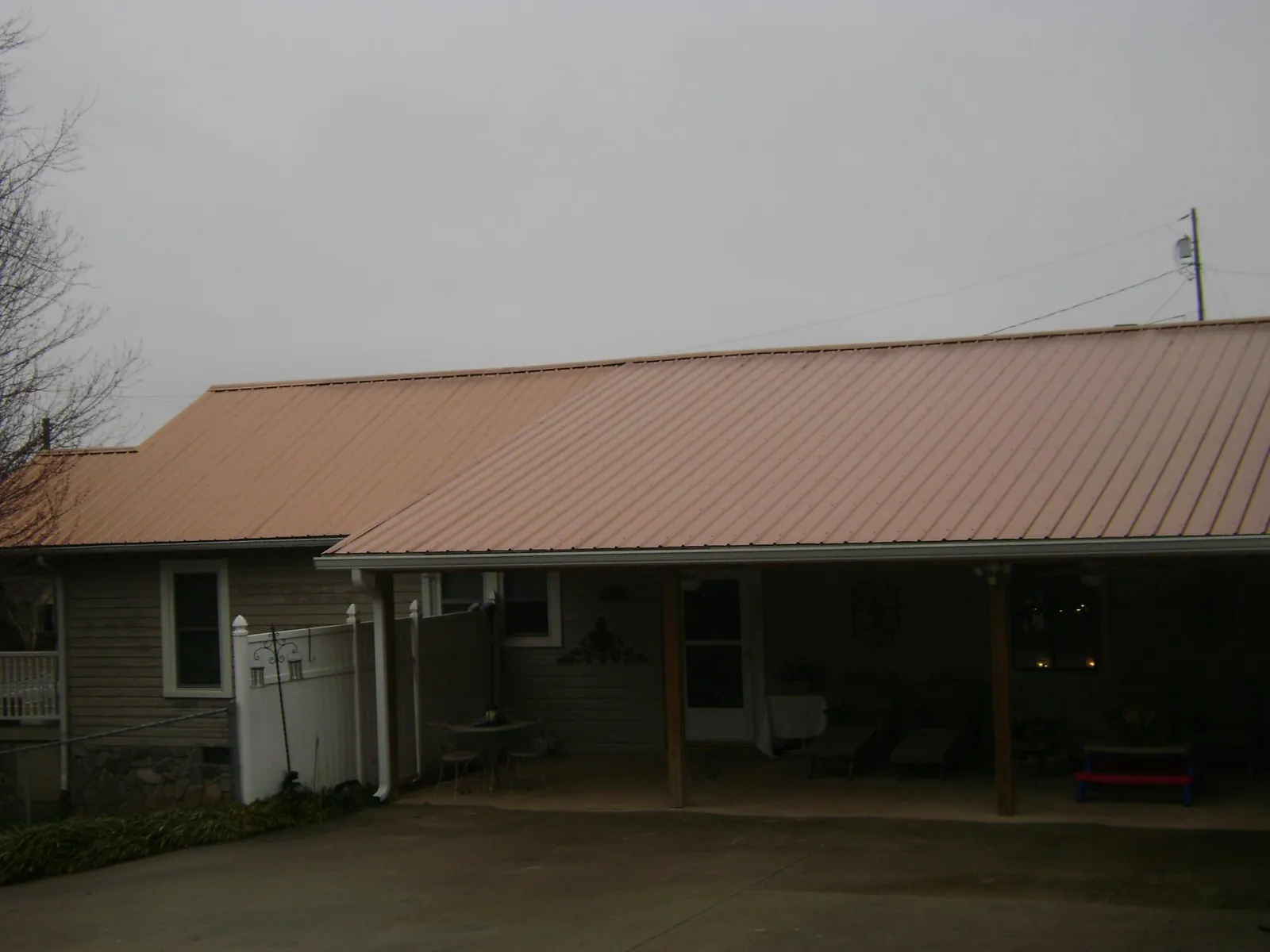 Copper toned metal roof over a wide covered patio in Countyline